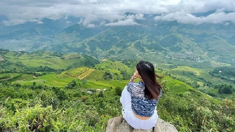 Traveller at a roadside viewpoint looking out over the Mu Cang Chai valley